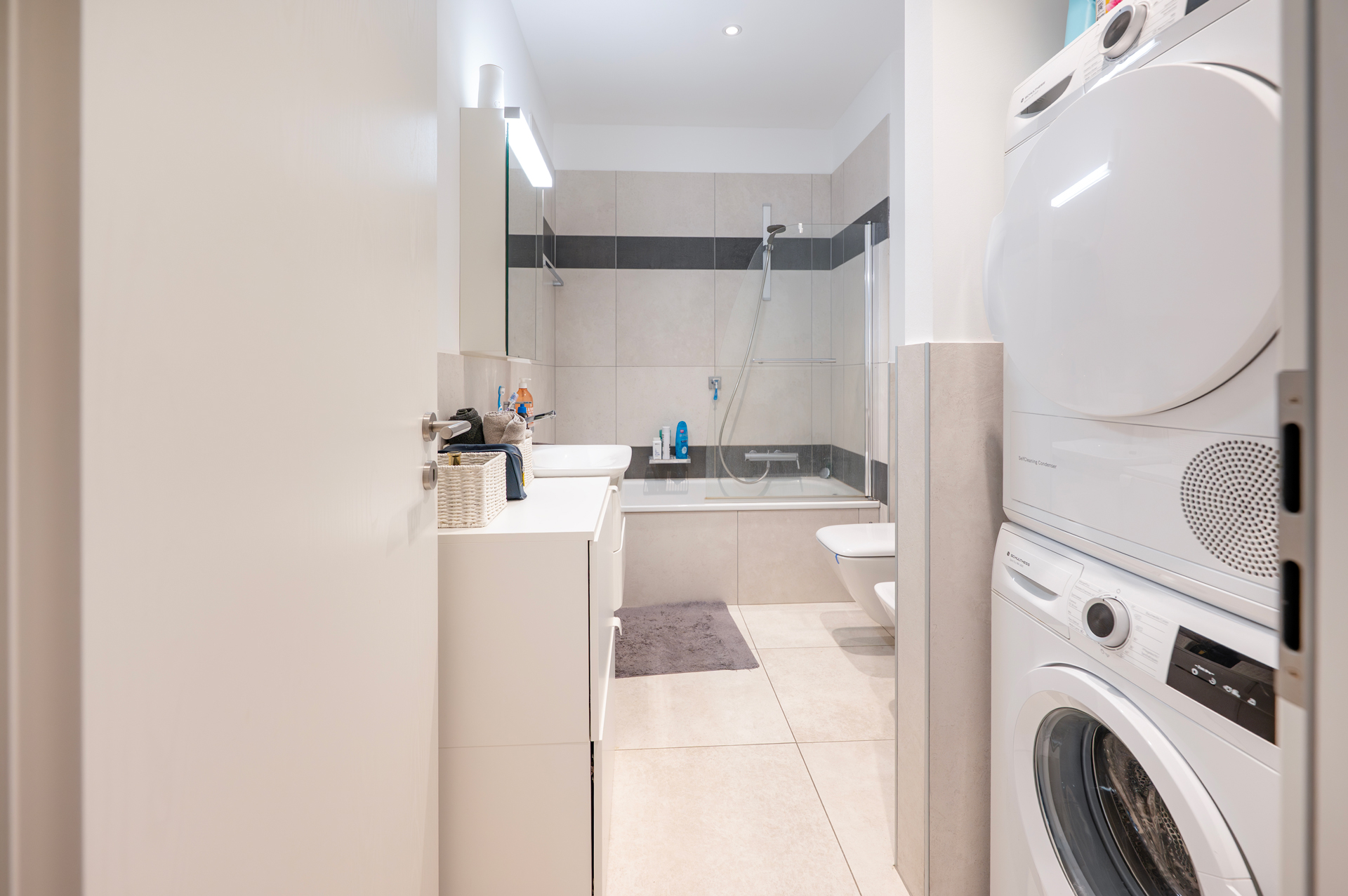 Helles, kompaktes Badezimmer mit Hauswirtschaftsbereich