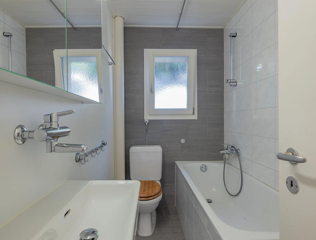 Kleines modernes Badezimmer mit Badewanne und WC