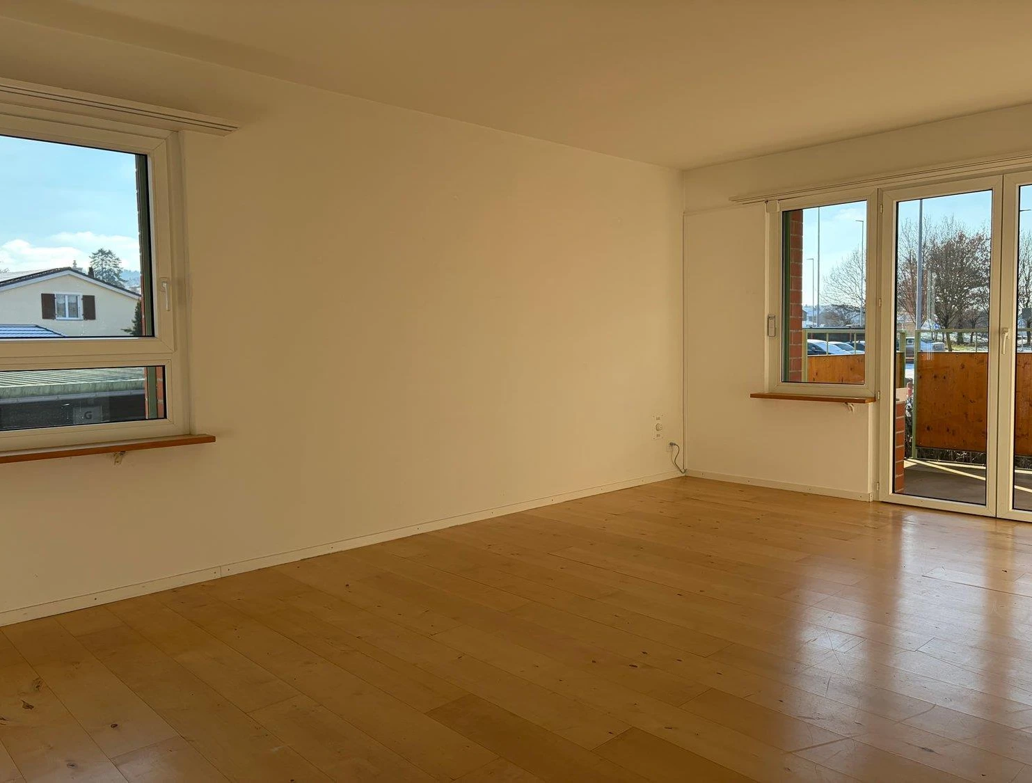 Leerer Wohnraum mit Balkonzugang