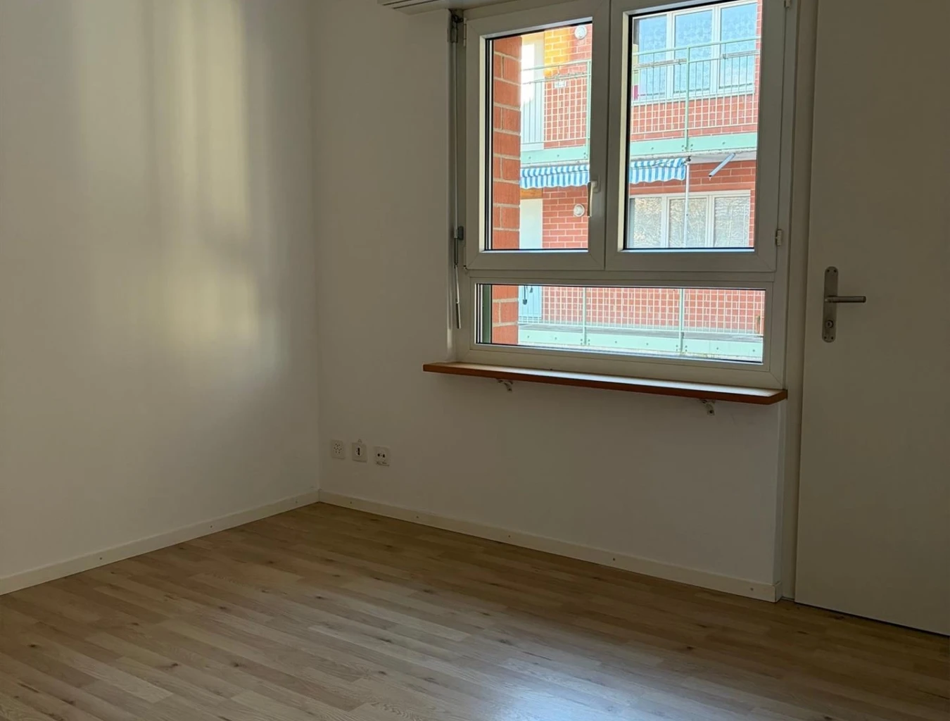Leerer Raum mit Fenster und Holzboden