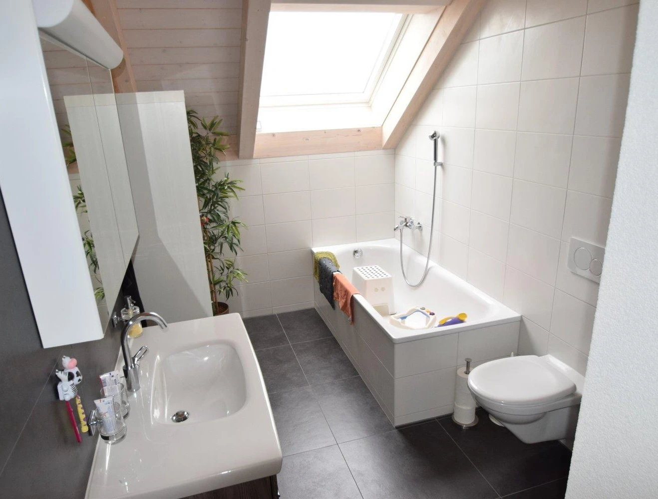 Dachgeschoss-Badezimmer mit Badewanne und Waschtisch