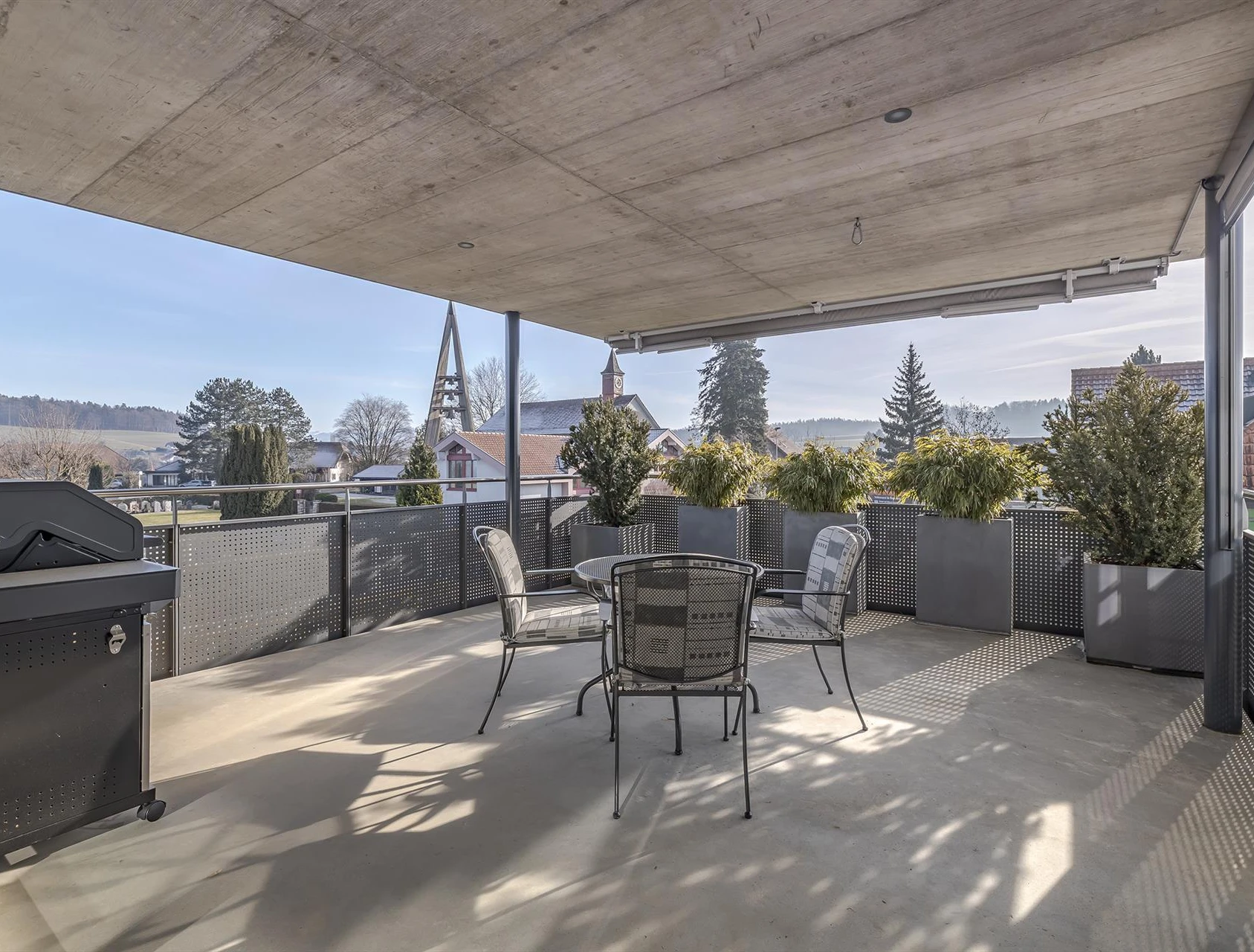 Überdachte Terrasse mit Sitzgruppe und Grill