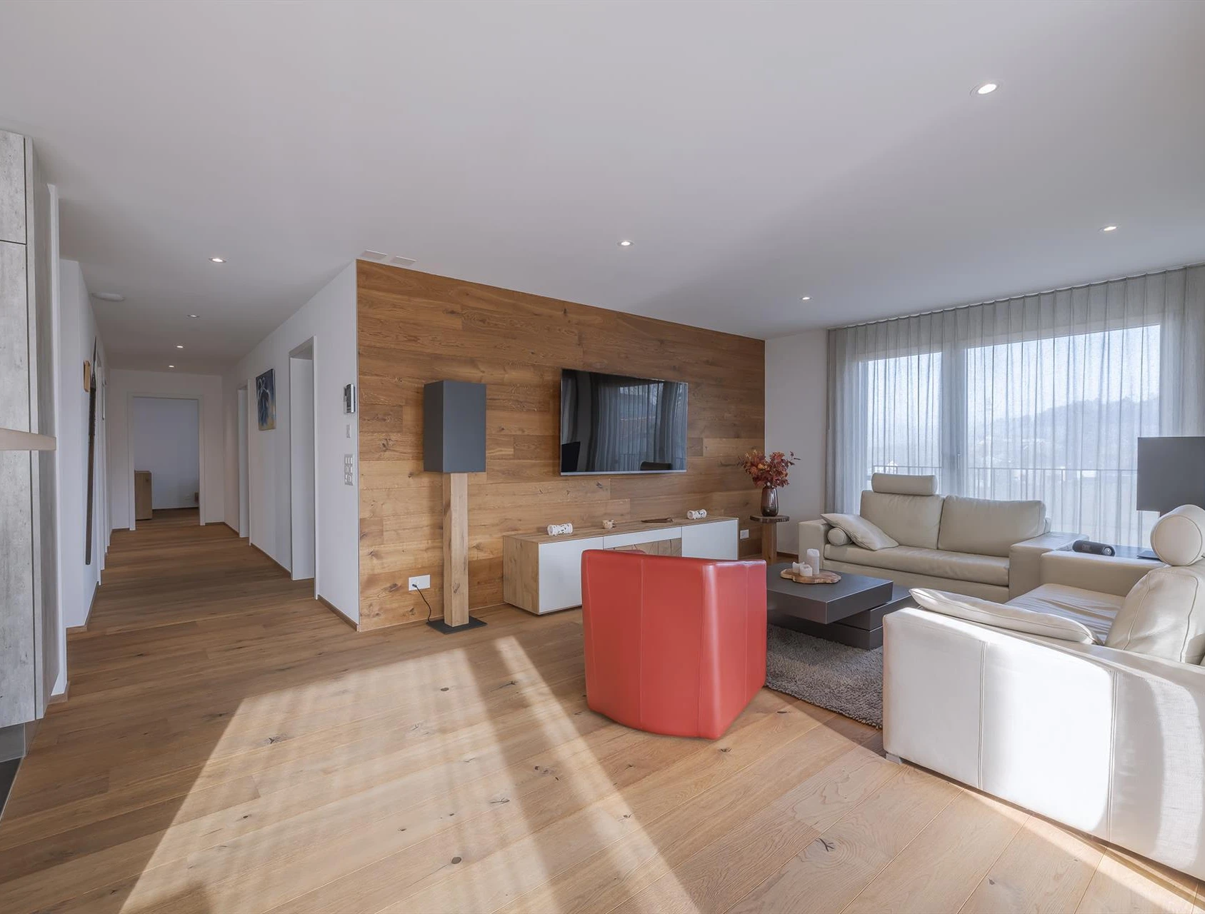 Modernes, helles Wohnzimmer mit Holzakzentwand