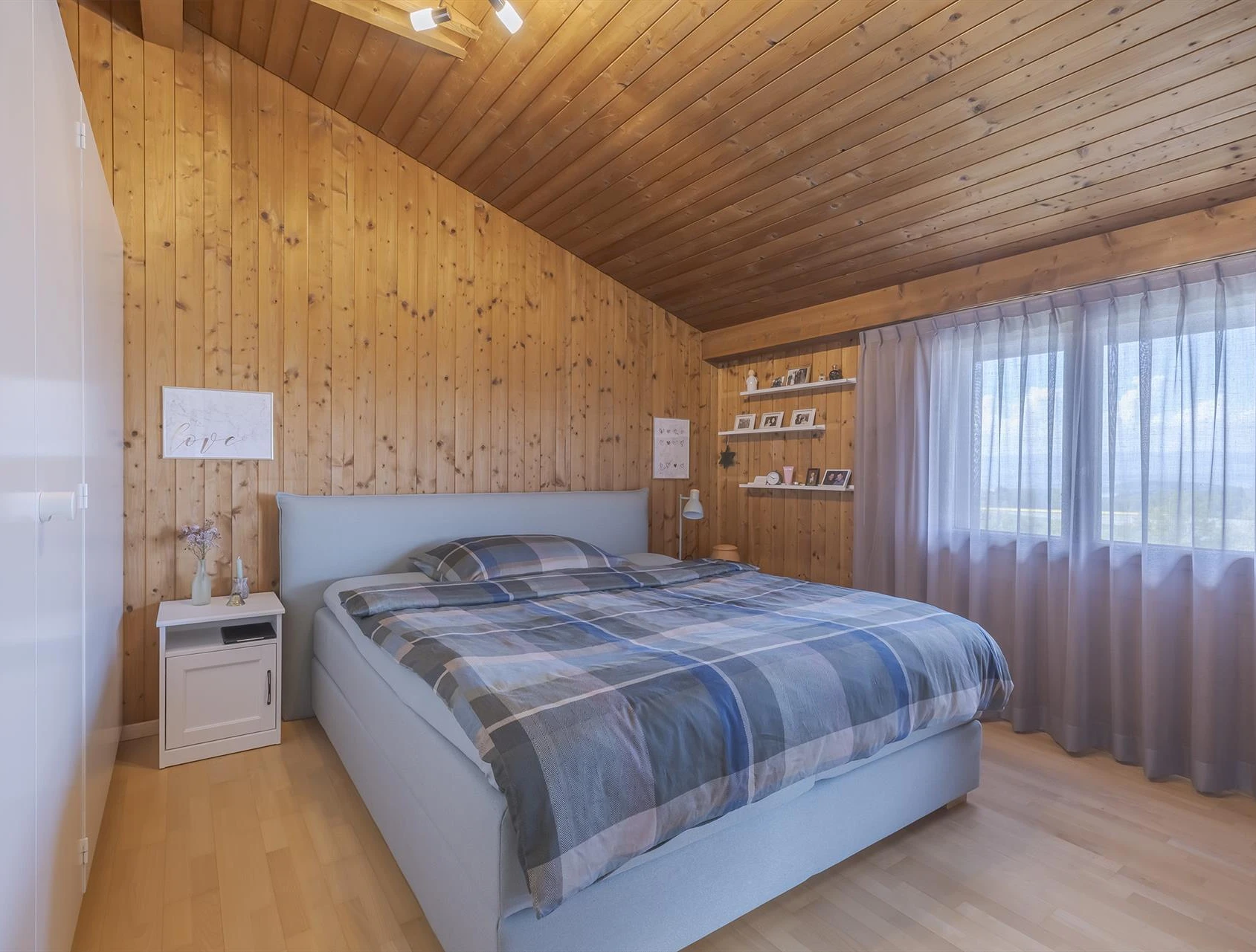Gemütliches Schlafzimmer mit Holzverkleidung