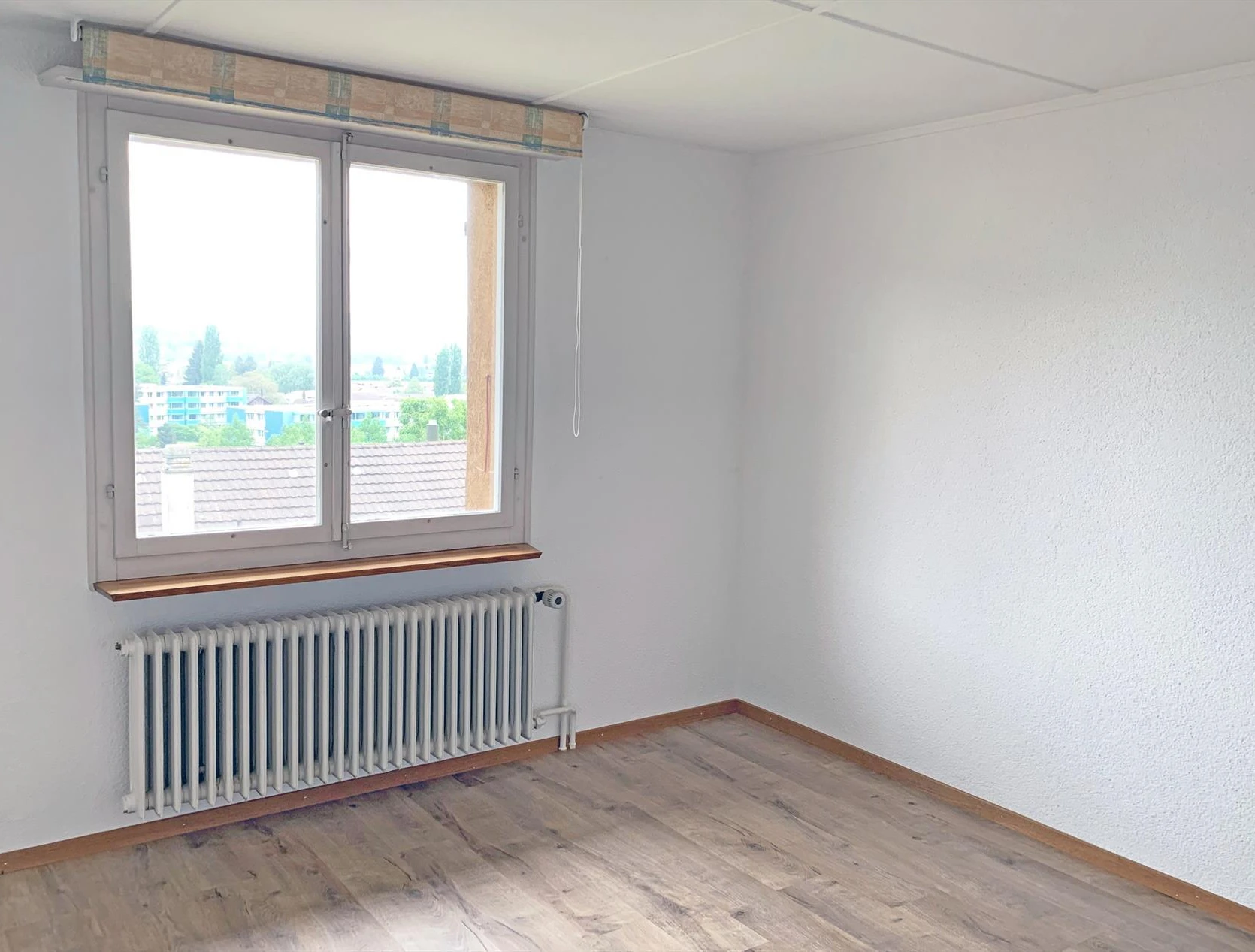 Helles leeres Zimmer mit Fenster und Heizkörper