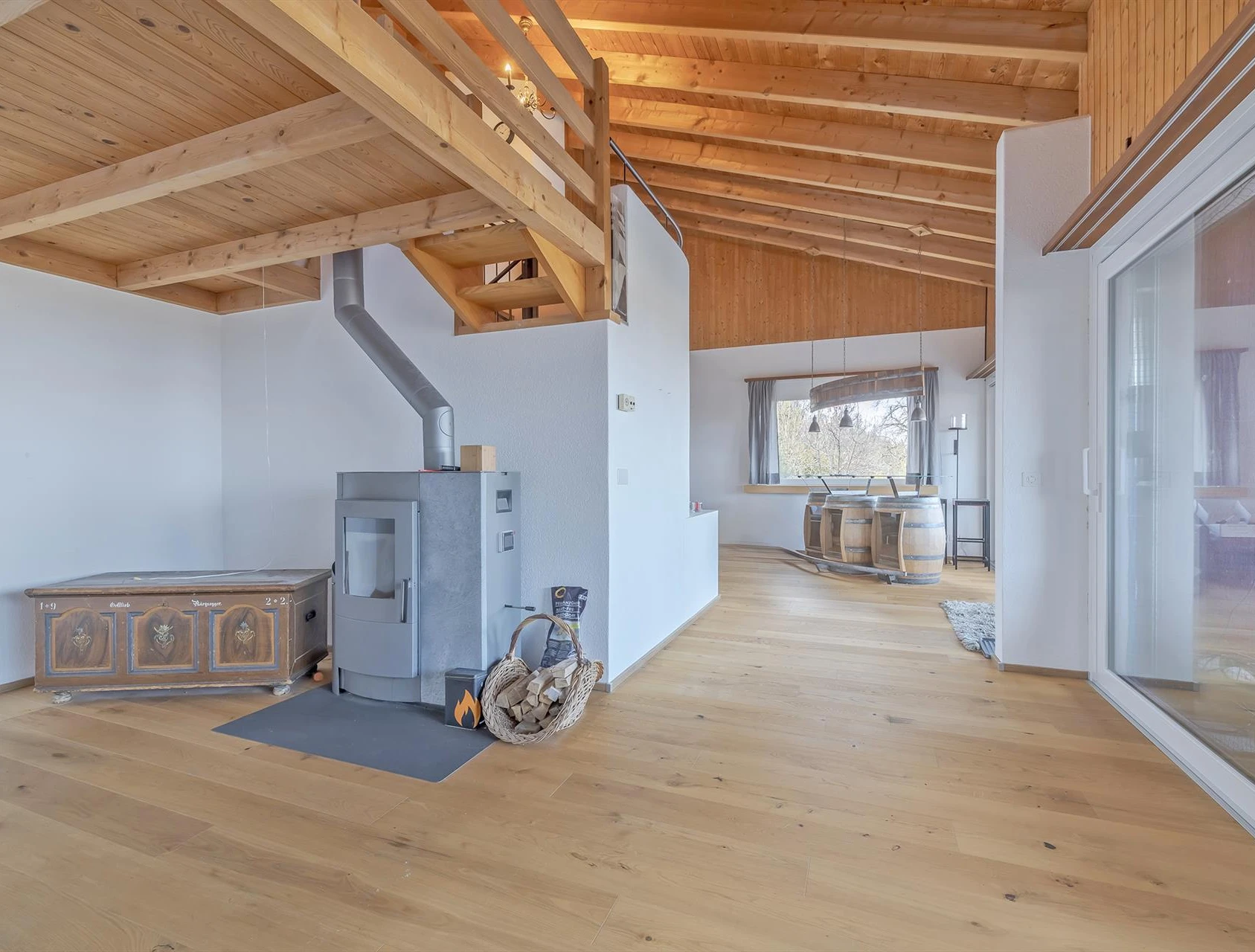 Offener Wohnbereich mit Holzofen und Galerie