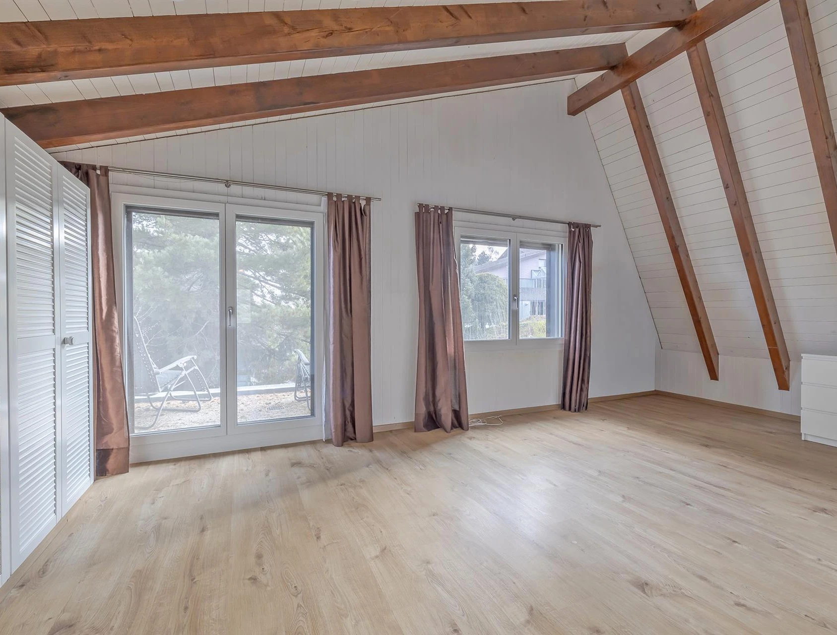 Helles Dachgeschosszimmer mit Holzdecke und Dachfenstern