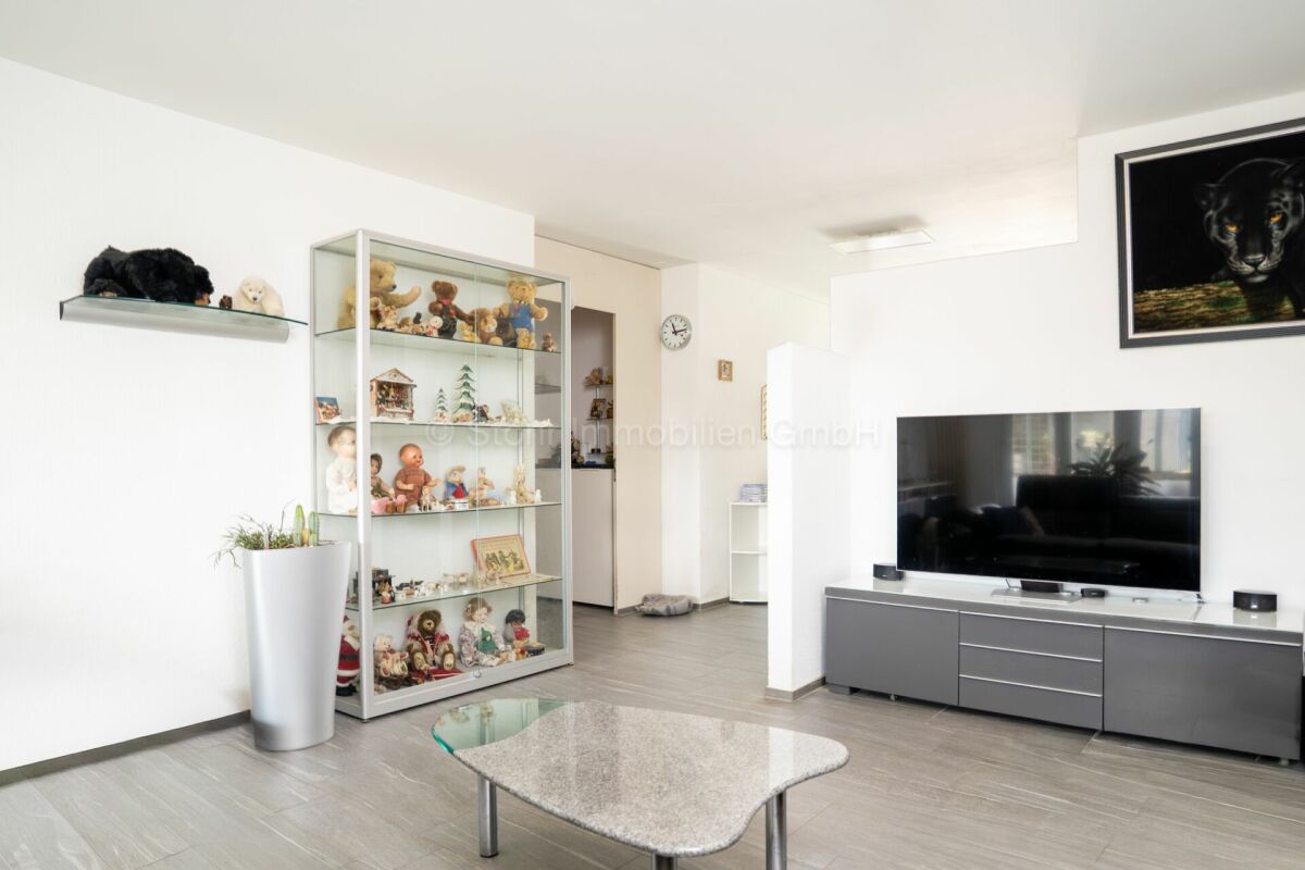 Heller Wohnraum mit TV-Wand und Vitrine