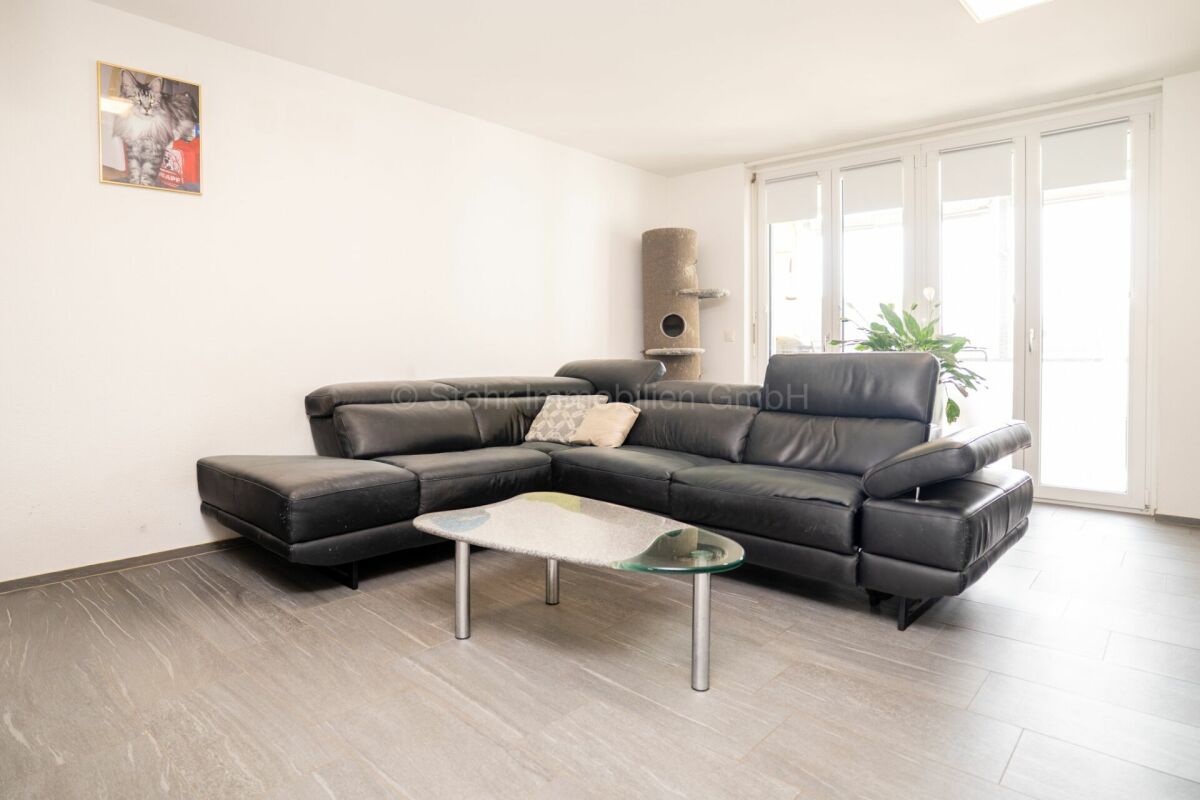 Helles Wohnzimmer mit schwarzer Eckcouch