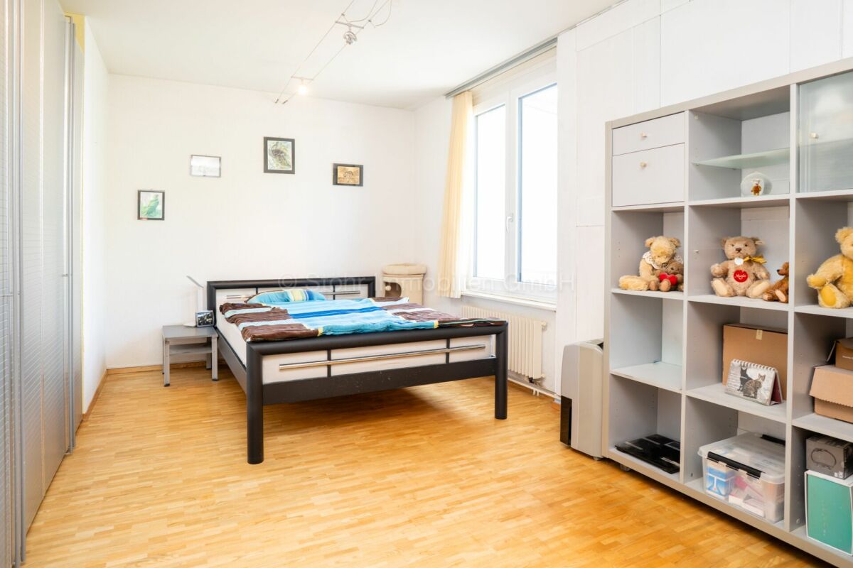 Helles Schlafzimmer mit Bett und Regalwand