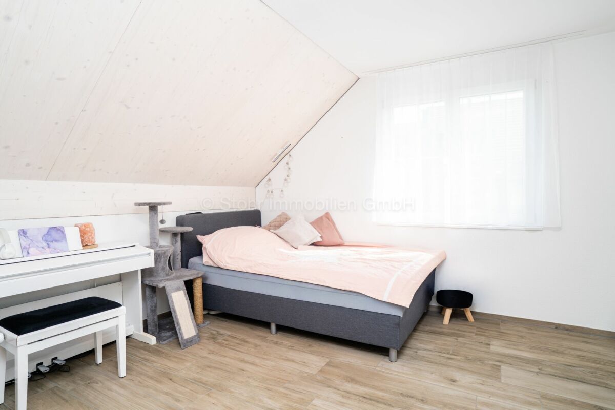 Dachgeschoss-Schlafzimmer mit heller Einrichtung