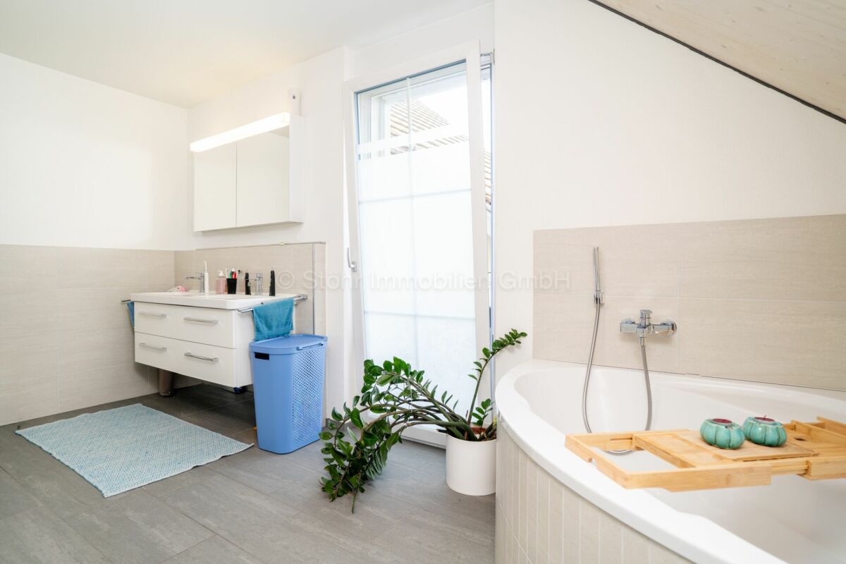Helles Badezimmer mit Badewanne und Waschtisch