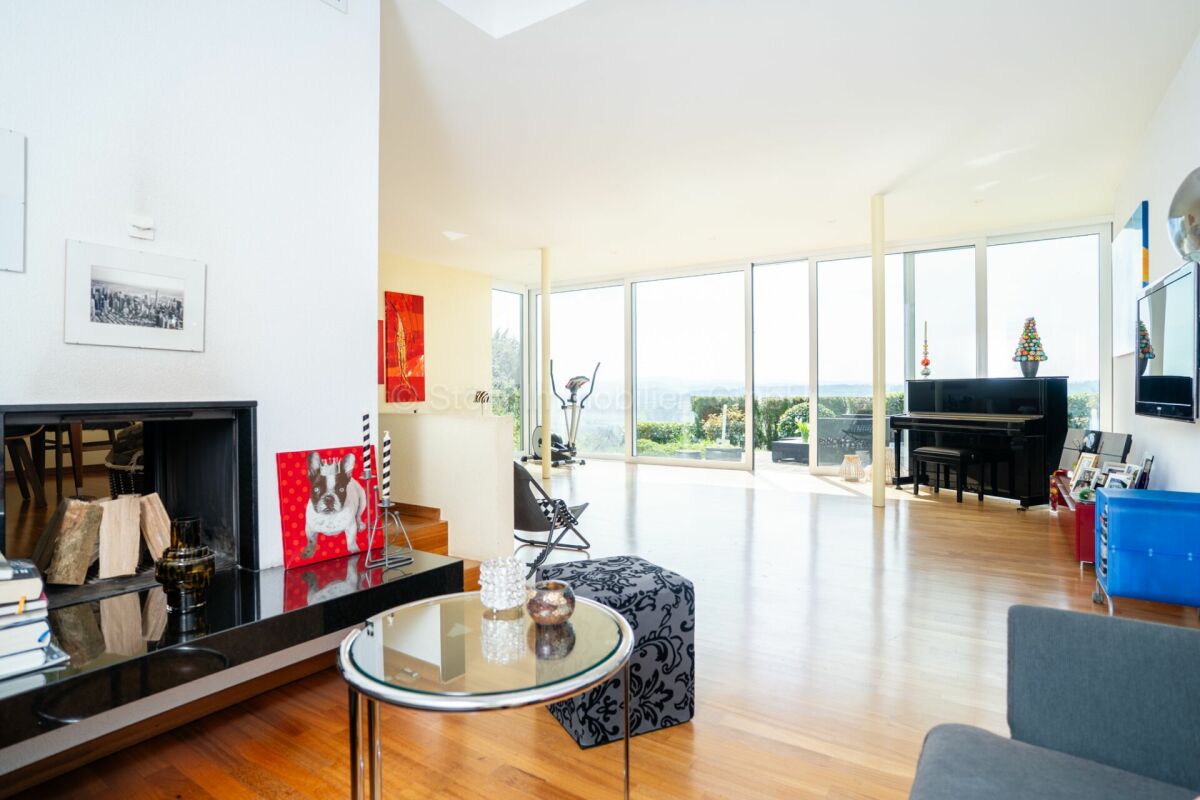 Moderner Wohnraum mit Panoramafenstern und Kamin