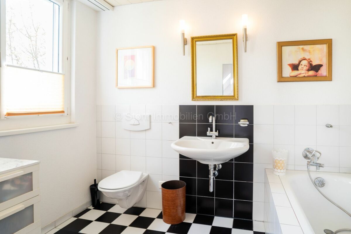 Helles Badezimmer mit klassischem Schwarz-Weiß-Boden