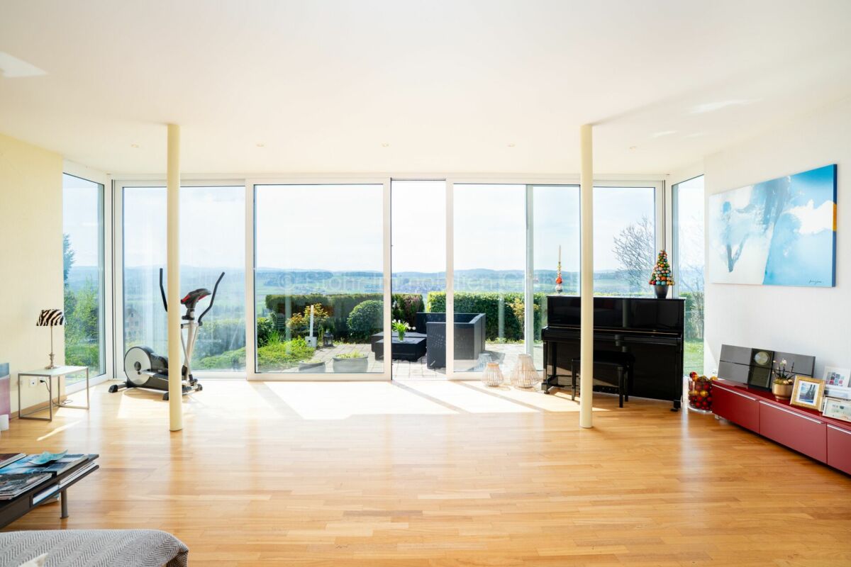 Heller Wohnraum mit Panoramafenstern und Gartenblick
