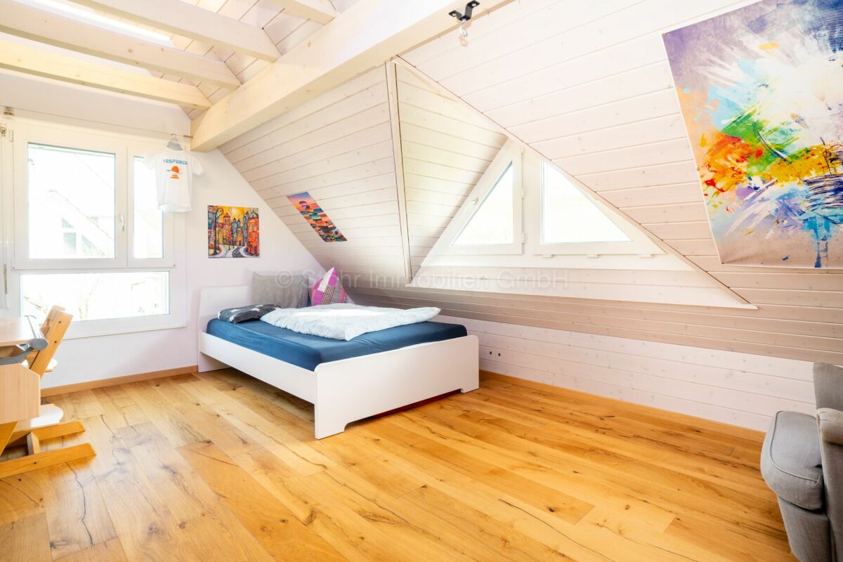 Helles Dachzimmer mit Bett