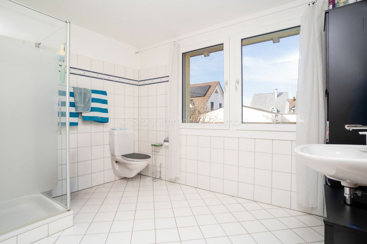 Helles Badezimmer mit Dusche, WC und Fenster