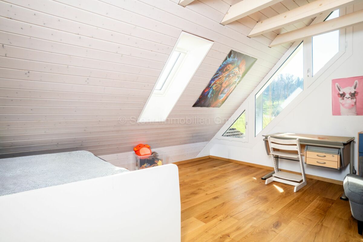 Dachzimmer mit Schreibtisch und Dachfenstern