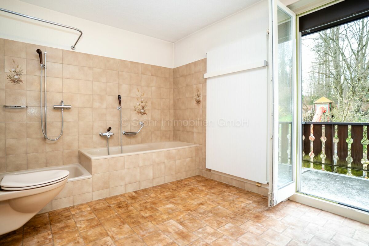 Badezimmer mit Wanne und Balkonblick