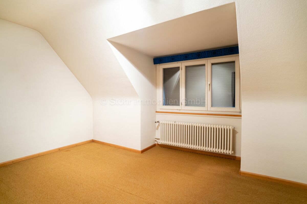 Dachzimmer mit Fenster und Heizkörper