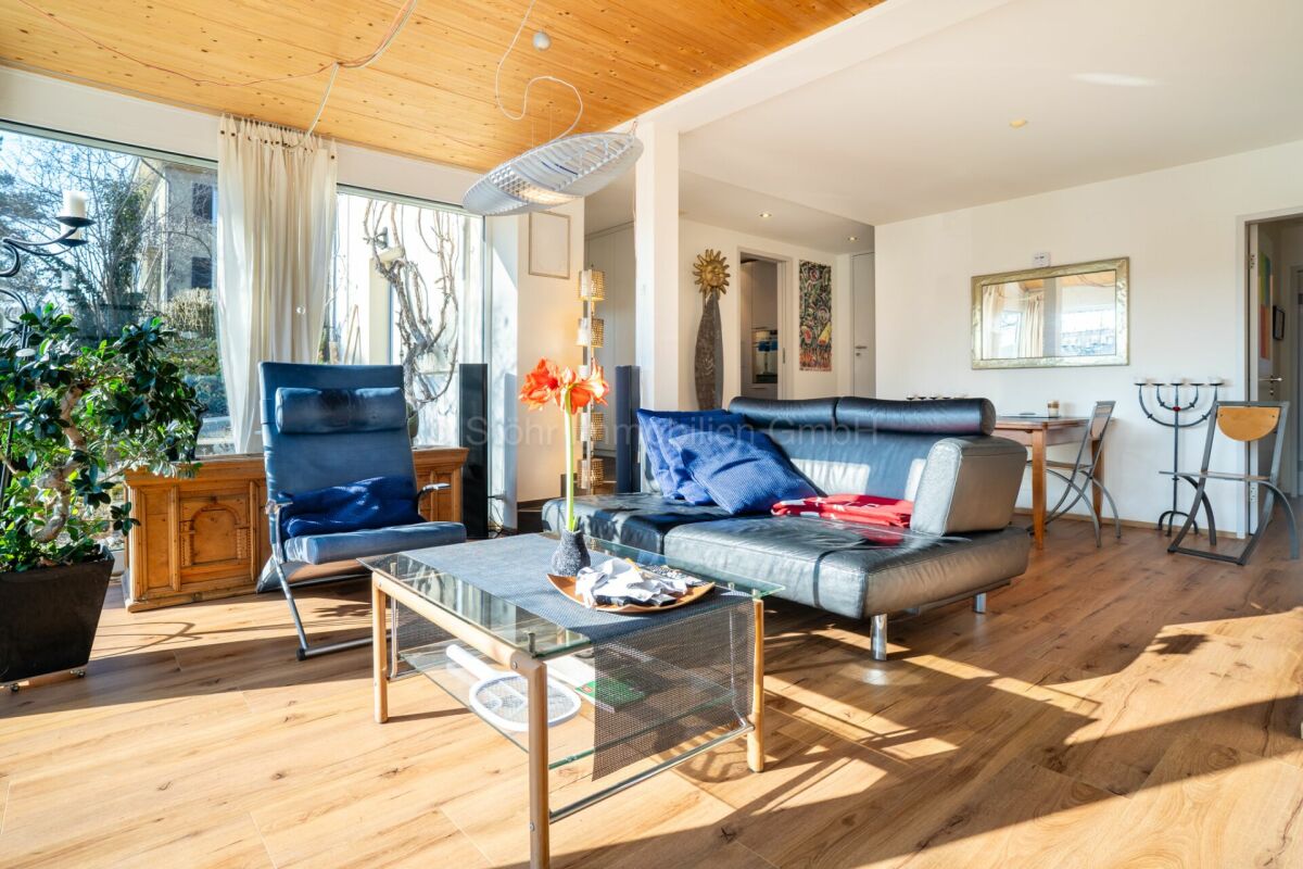 Helles Wohnzimmer mit großem Fenster und Holzbalkendecke