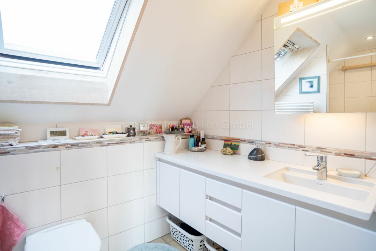 Helles Dachbad mit Dachfenster und Waschplatz
