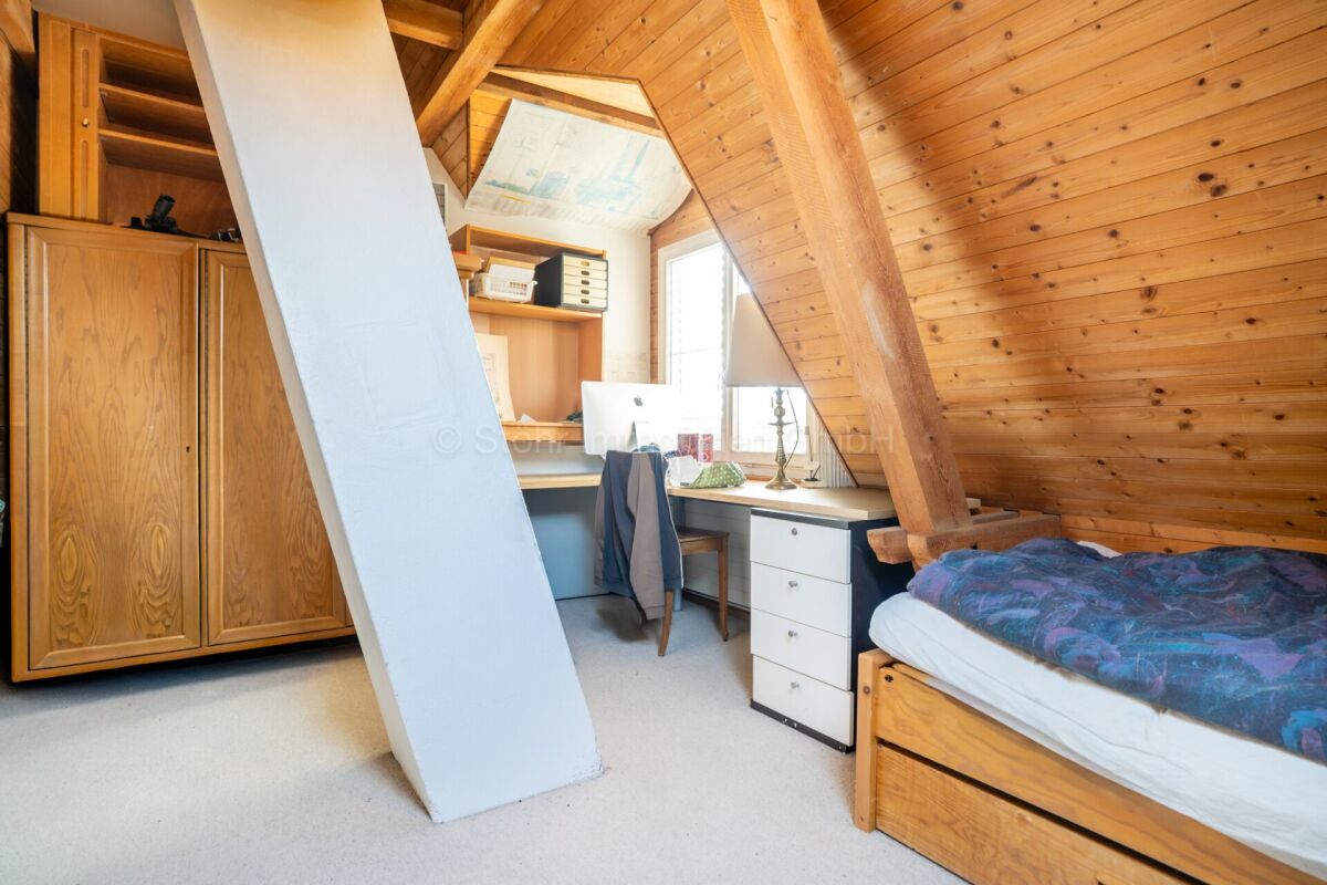 Dachzimmer mit Arbeitsplatz und Bett