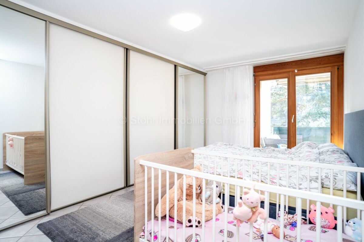 Kinderzimmer mit Einbauschrank und Balkonfenster