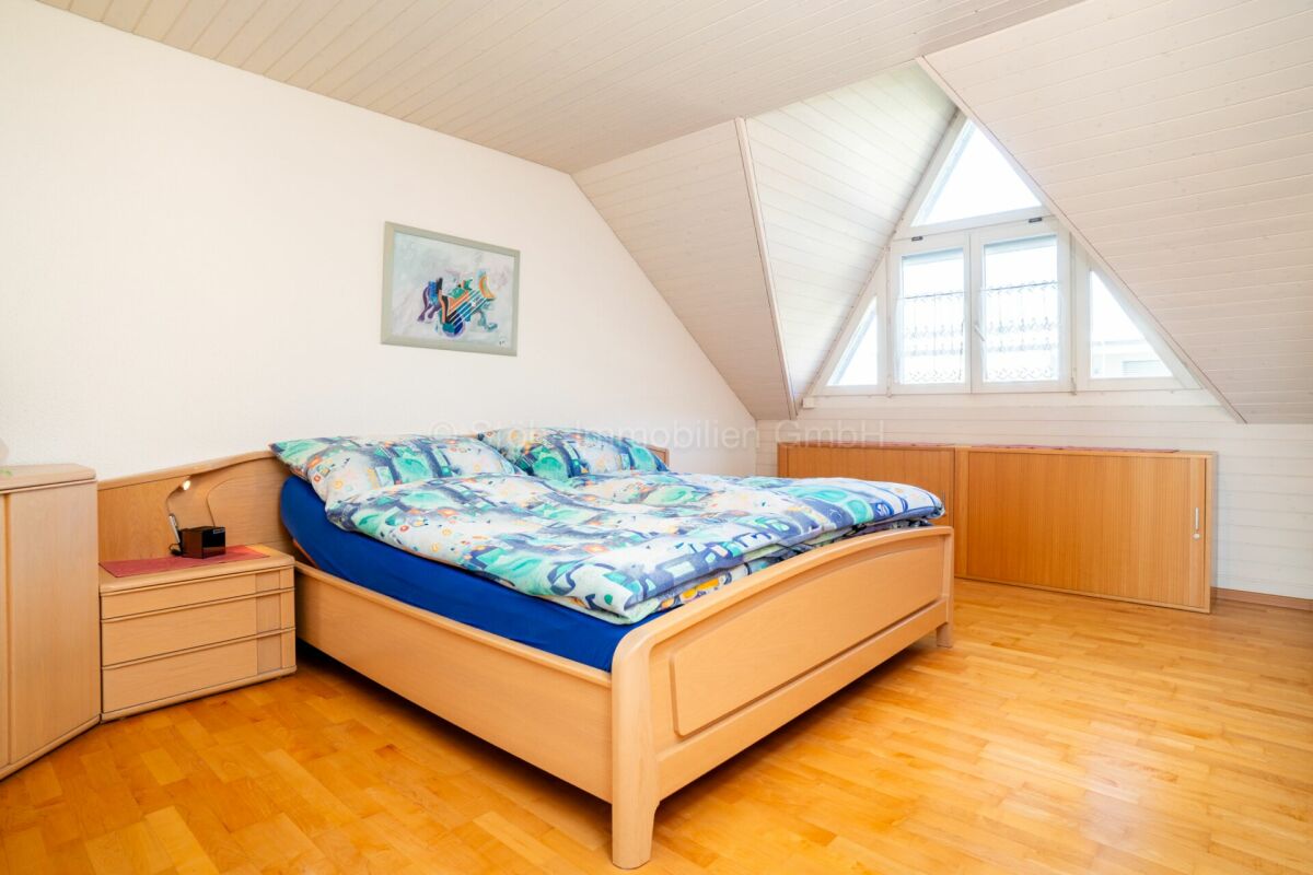 Dachgeschoss-Schlafzimmer mit Doppelbett und Dachfenstern