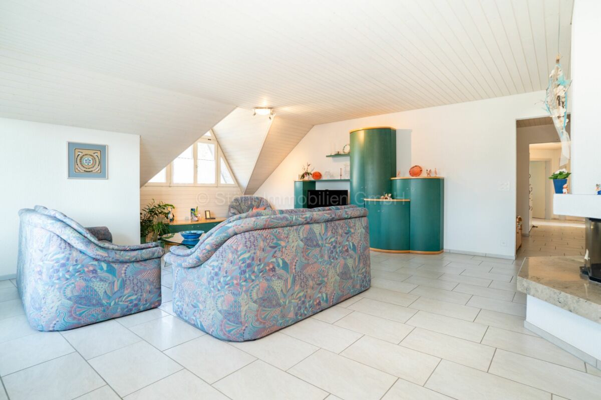 Helles Dachgeschoss-Wohnzimmer mit pastellfarbenen Sitzmöbeln