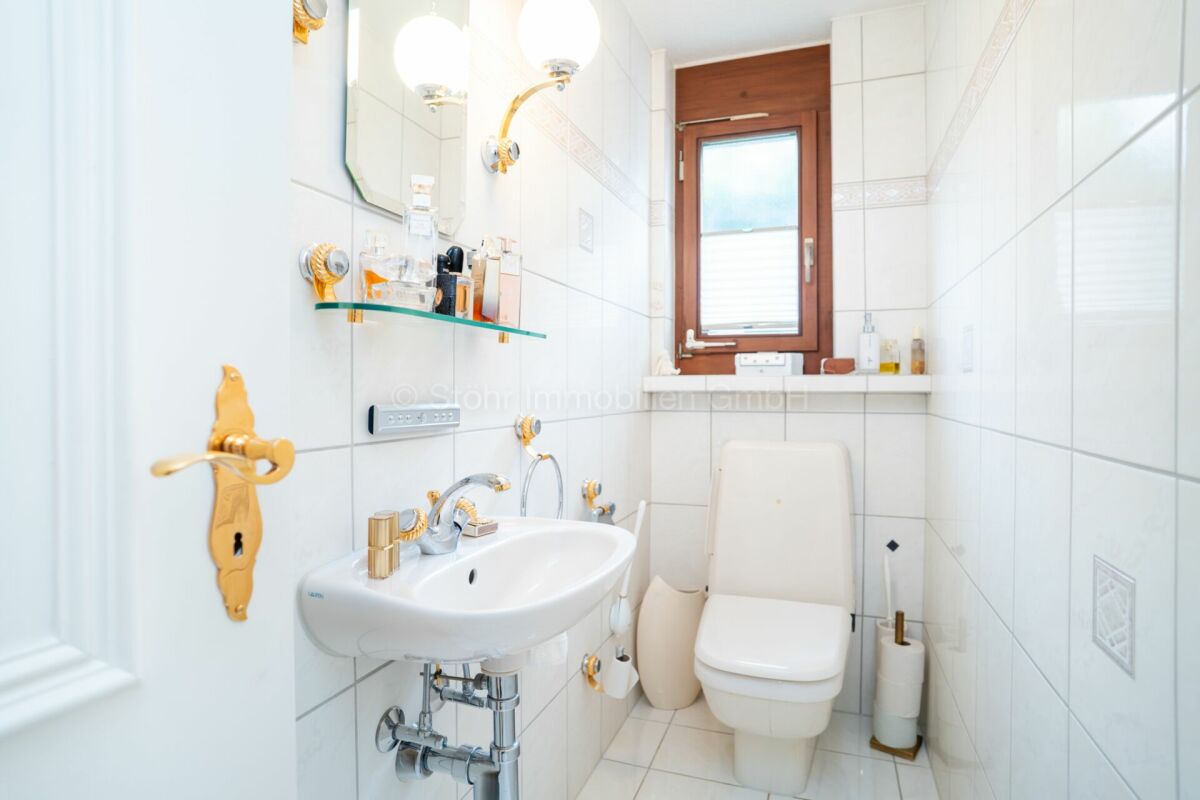 Gäste-WC mit goldenen Armaturen