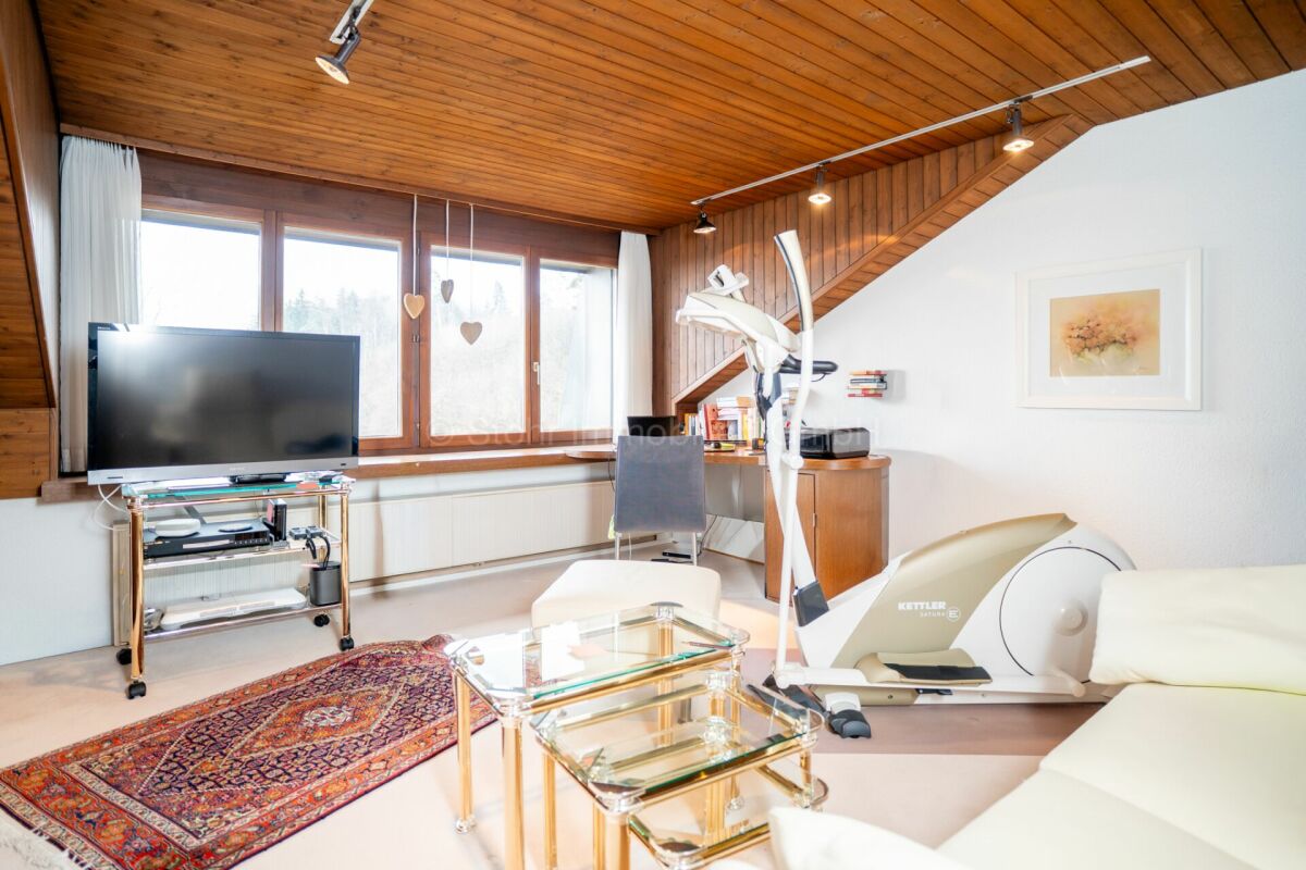 Heller Wohnraum mit Holzdecke und Heimtrainingsbereich