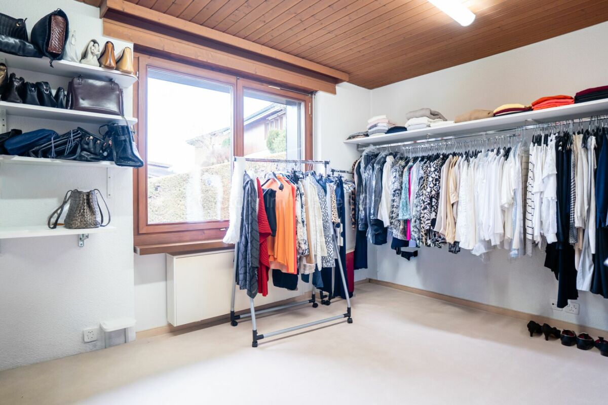 Ankleidezimmer mit Kleiderstangen und Fenster