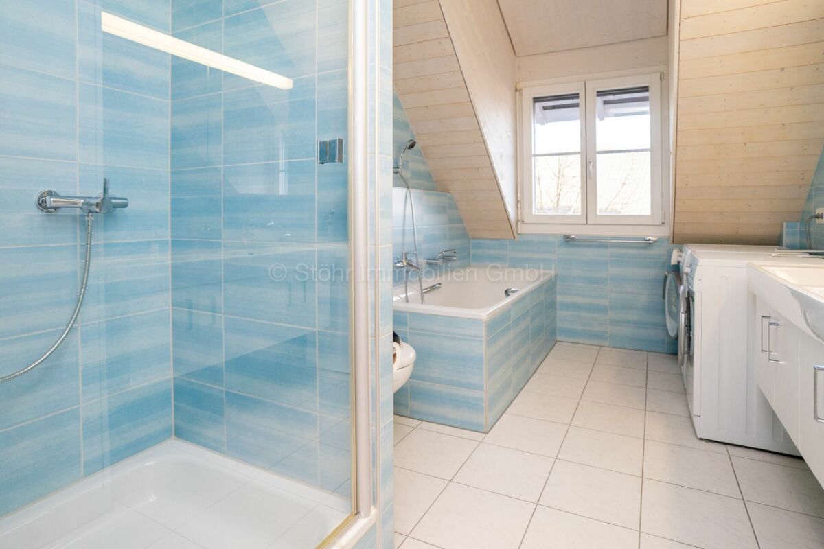 Badezimmer mit Dusche und Wannenbereich