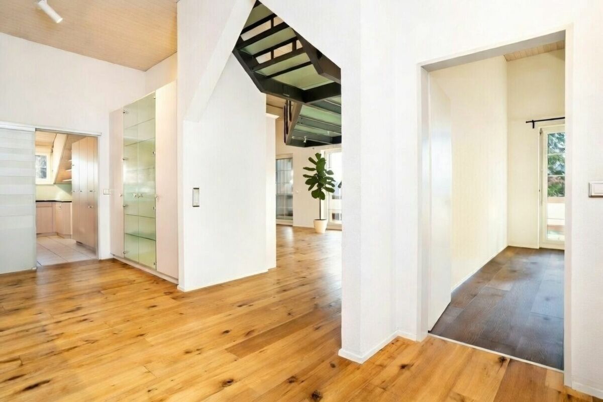 Heller Flur mit offenem Wohnbereich und Galerie-Treppe