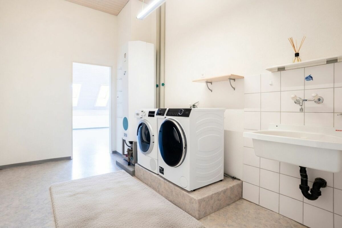 Hauswirtschaftsraum mit Waschmaschinen und Waschbecken