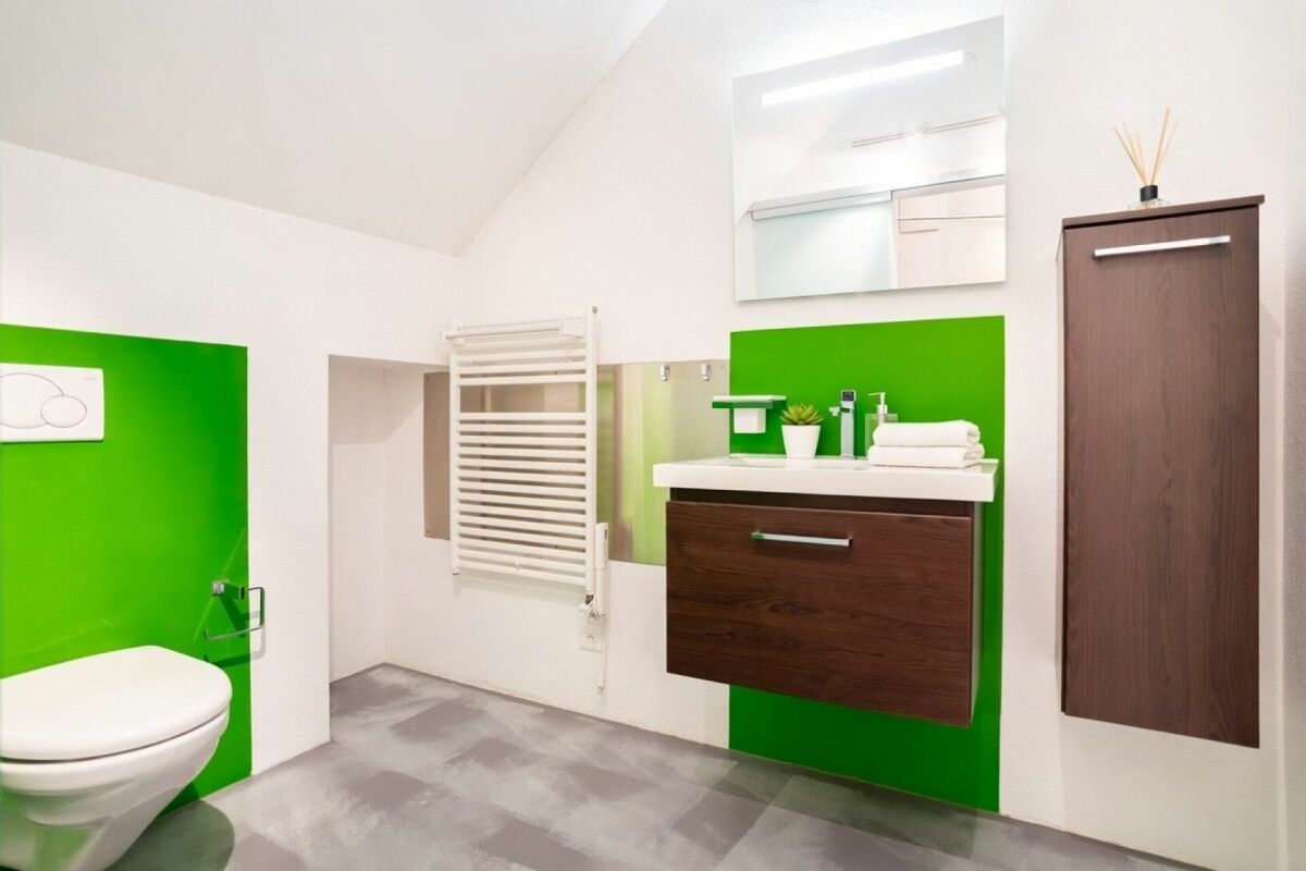 Modernes Badezimmer mit grün akzentuierten Wandflächen