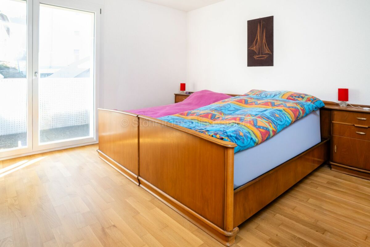 Schlafzimmer mit Holzbett und Balkonfenster