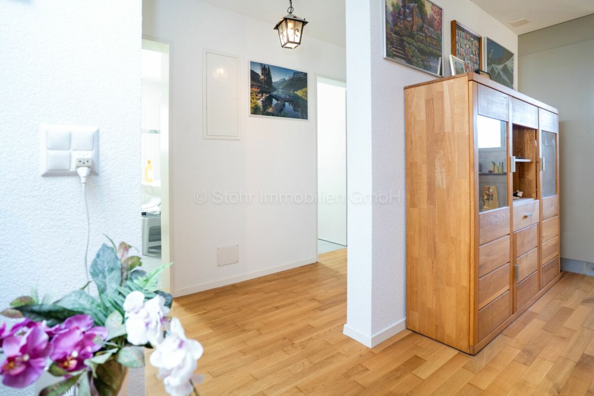 Heller Eingangsbereich mit Holzvitrine