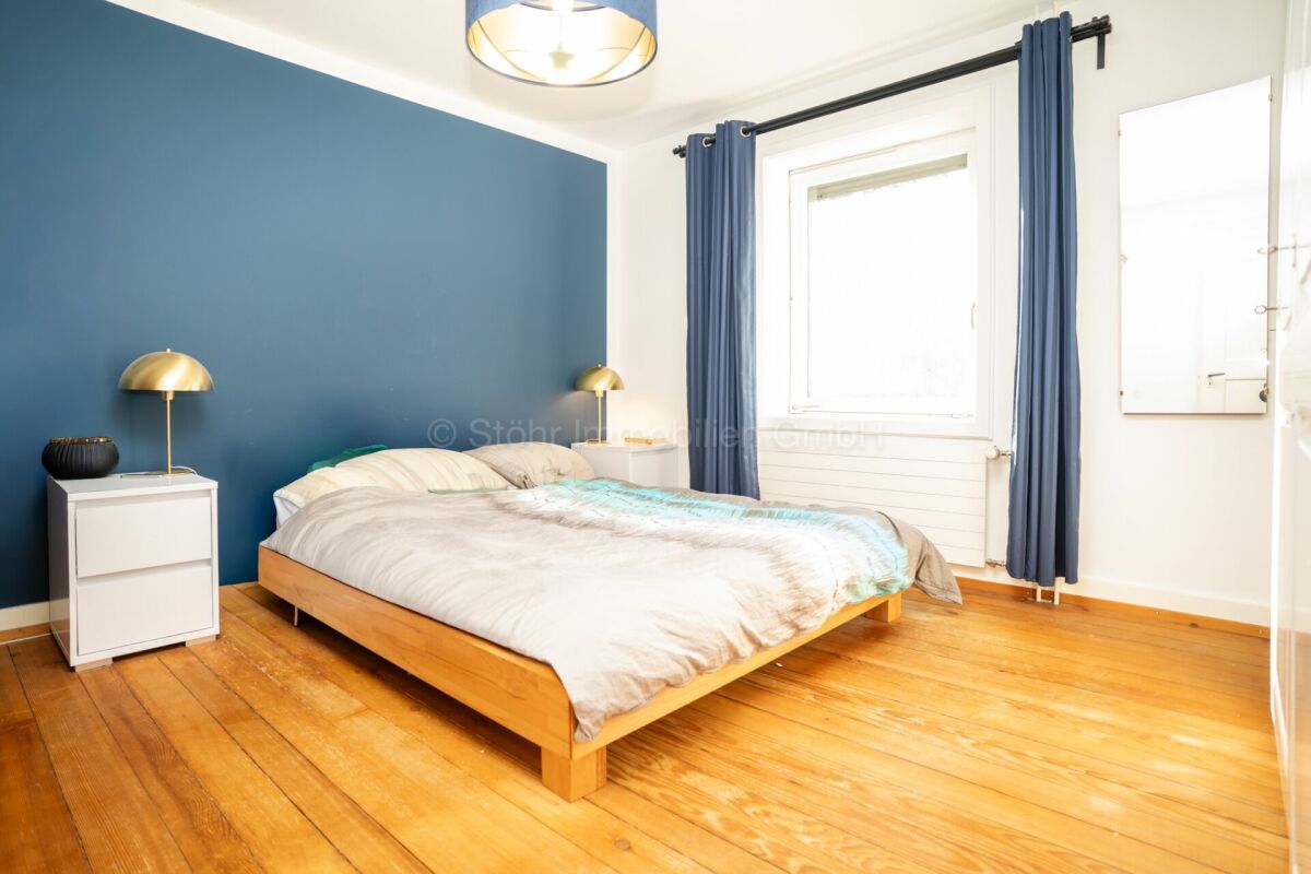Schlafzimmer mit blauem Akzent und Holzfußboden