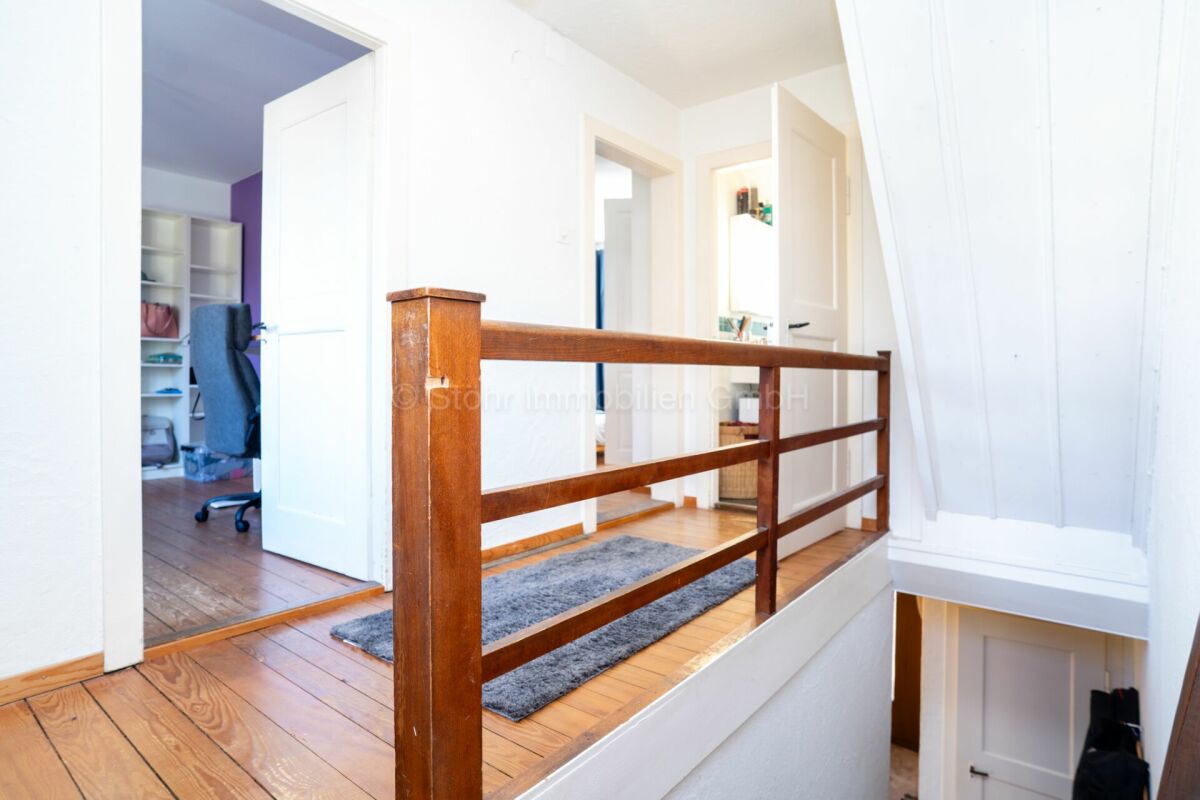 Heller Flur mit Holzgeländer