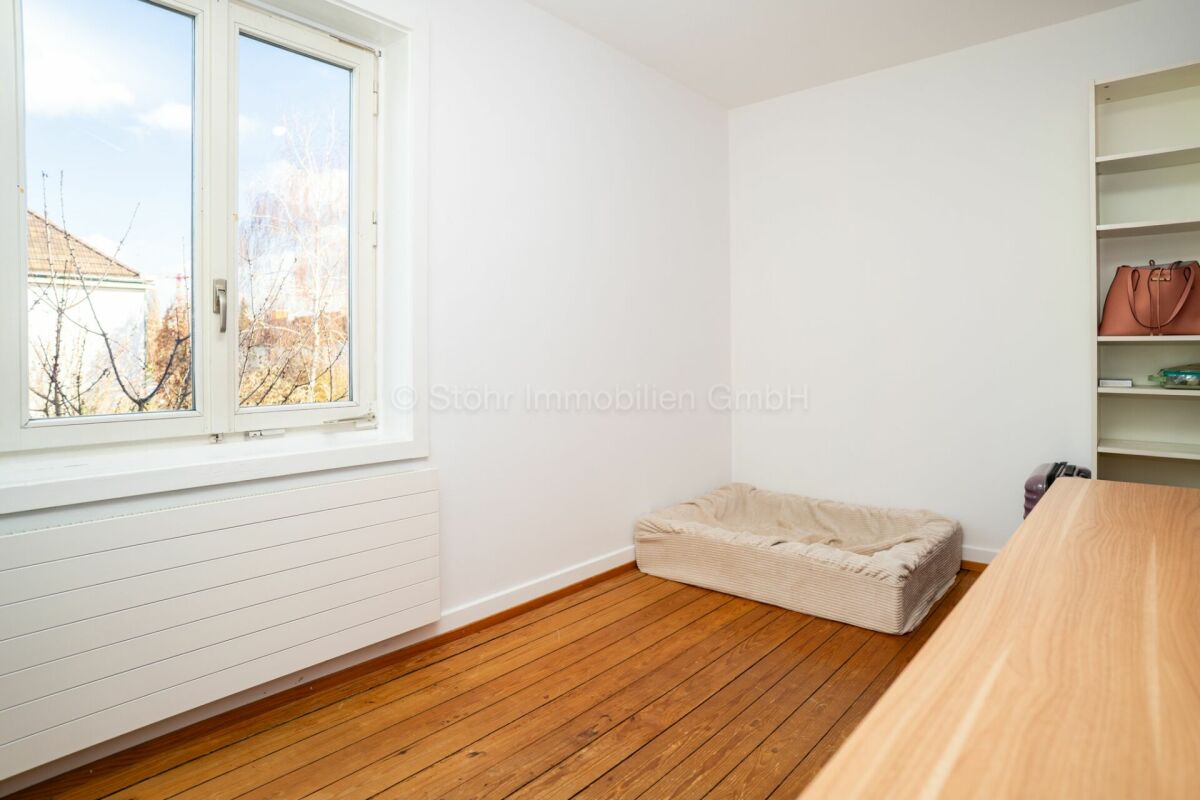 Helles kleines Zimmer mit Holzfußboden und Einbauregal