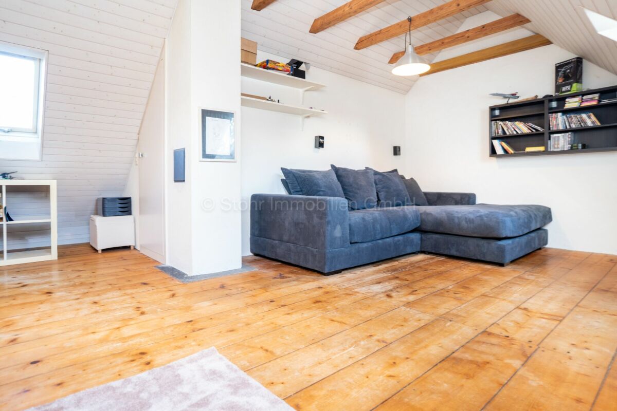 Dachgeschoss-Wohnzimmer mit Holzboden und Balken