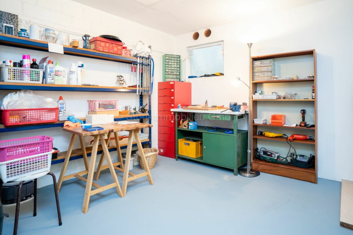 Werkstatt-/Abstellraum mit Regalen und Arbeitstischen