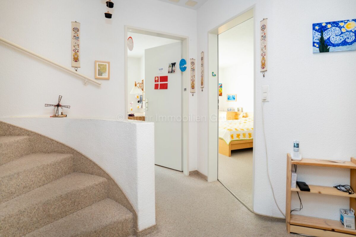 Treppenhaus mit Blick in einen Flur und ein Schlafzimmer