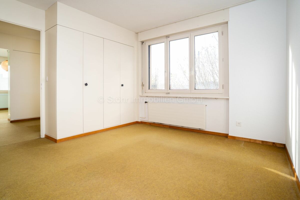 Heller, leerer Wohnraum mit Einbauschrank und Fenster