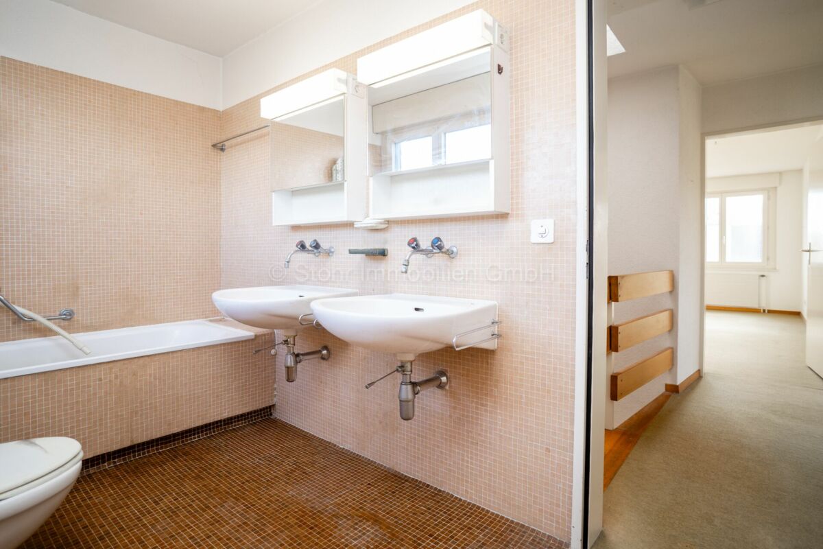 Badezimmer mit Doppelwaschtisch und Badewanne