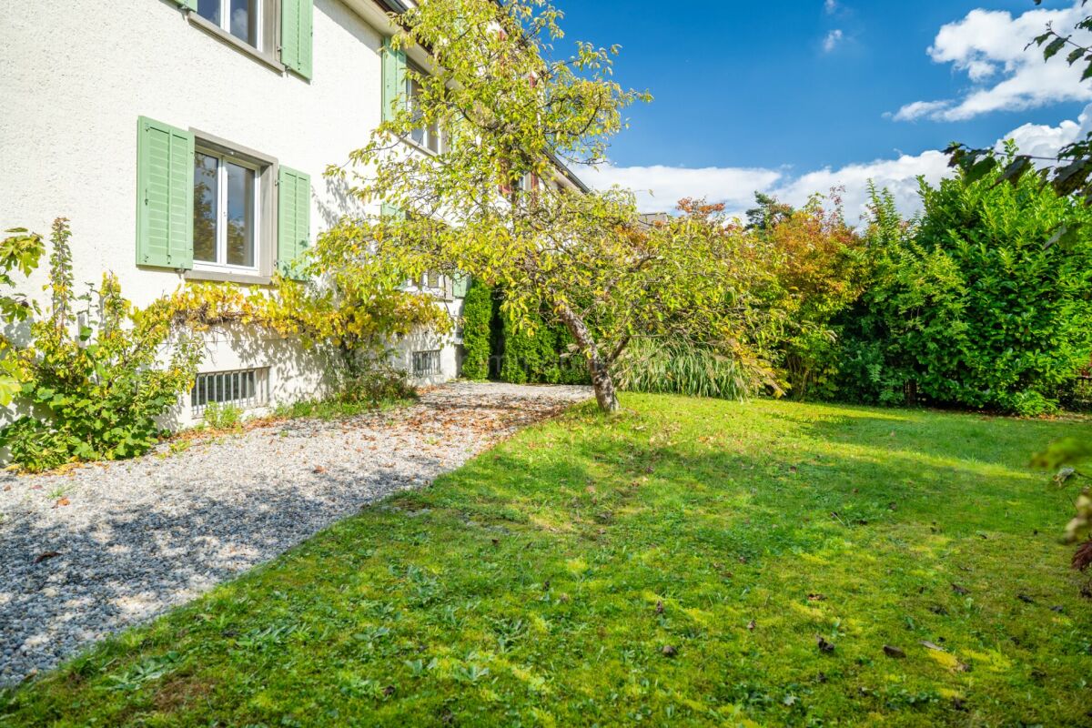 Gartenansicht eines Hauses mit Rasen und Kiesweg