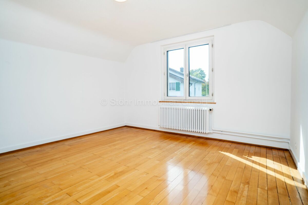 Heller leerer Raum mit Parkettboden und Fenster