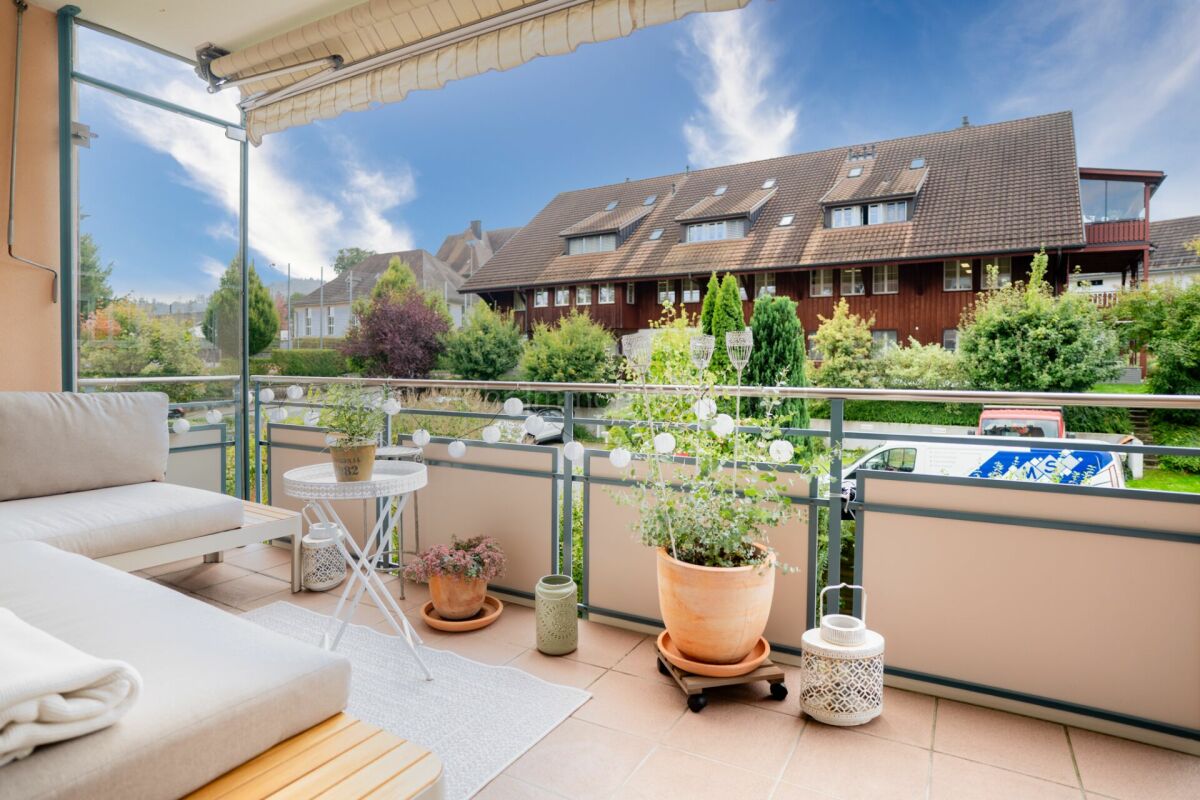 Balkon mit Sitzbereich und Blick auf Wohnhäuser